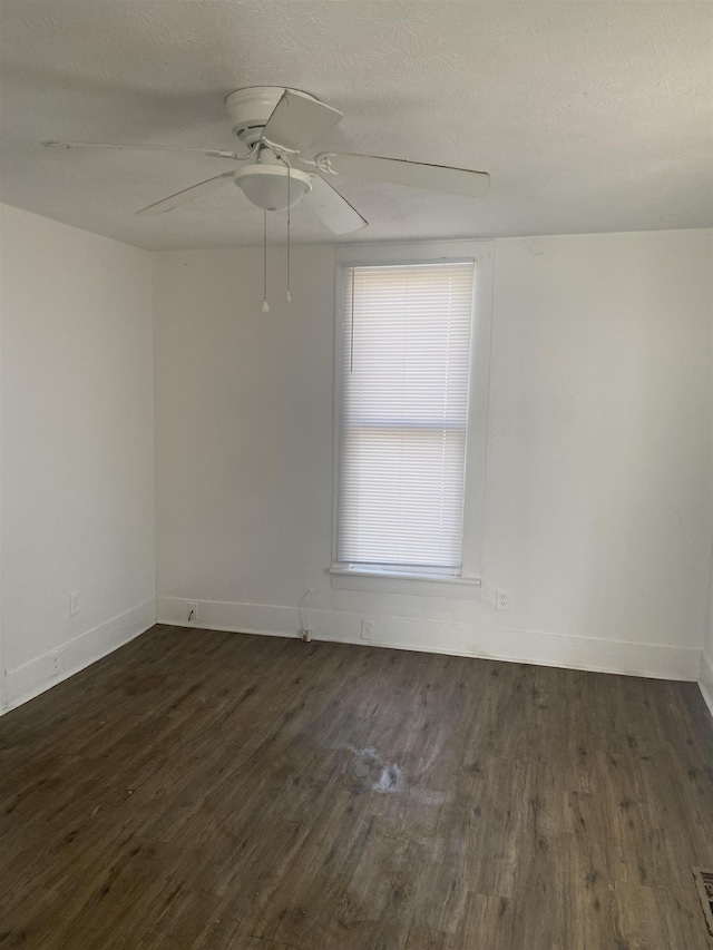 unfurnished room with a textured ceiling, dark wood-type flooring, and ceiling fan