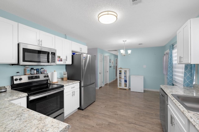 kitchen featuring white cabinetry, stainless steel appliances, and light hardwood / wood-style floors