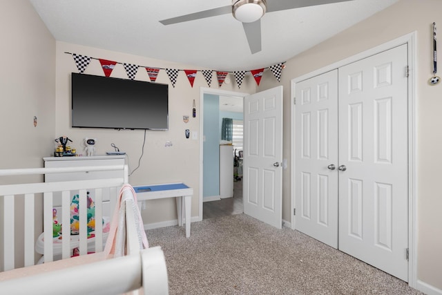 bedroom featuring ceiling fan, carpet floors, a closet, and a crib