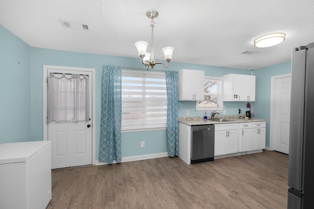 kitchen with sink, white cabinetry, hanging light fixtures, stainless steel appliances, and light wood-type flooring