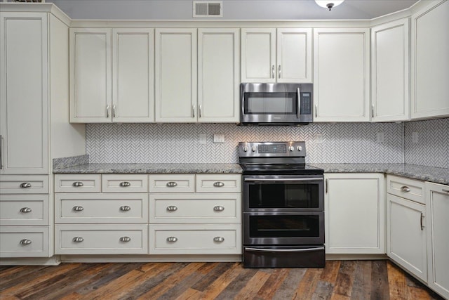 kitchen featuring light stone countertops, appliances with stainless steel finishes, dark hardwood / wood-style floors, and backsplash