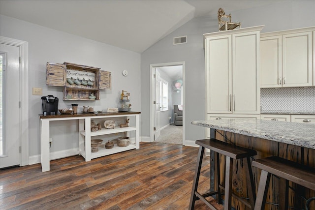 interior space featuring lofted ceiling and dark wood-type flooring