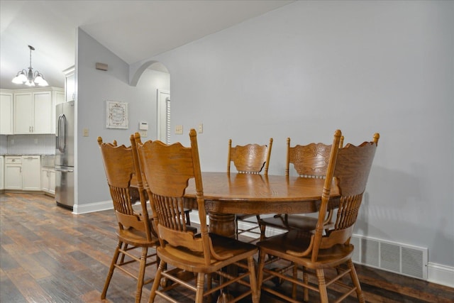 dining space featuring lofted ceiling, a notable chandelier, and dark hardwood / wood-style floors