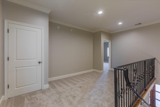 corridor with ornamental molding and light colored carpet