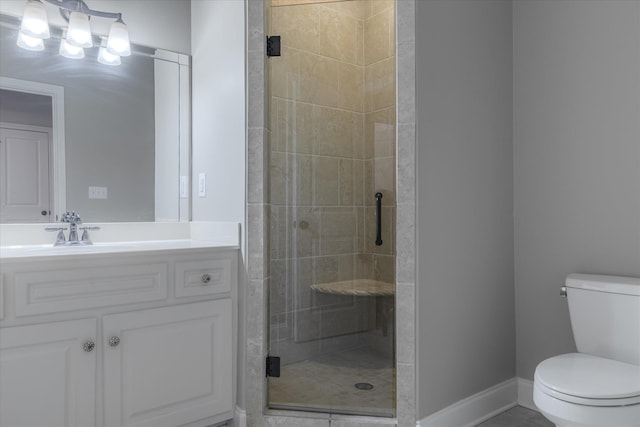 bathroom featuring vanity, a shower with shower door, and toilet