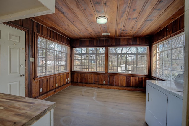 unfurnished sunroom featuring a healthy amount of sunlight, separate washer and dryer, and wooden ceiling