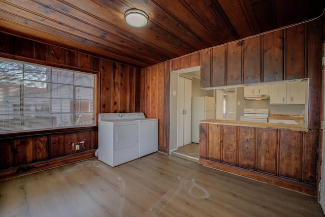 laundry area with wooden walls, separate washer and dryer, light hardwood / wood-style floors, and wooden ceiling