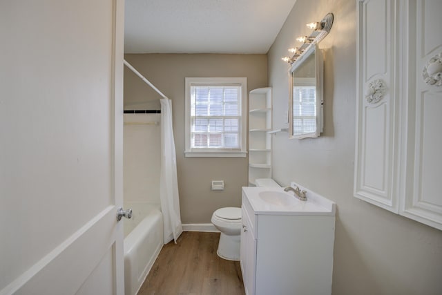 full bathroom with shower / tub combo, vanity, wood-type flooring, a textured ceiling, and toilet