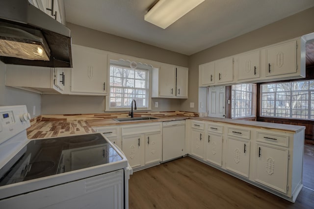 kitchen with sink, white cabinetry, light hardwood / wood-style flooring, kitchen peninsula, and white appliances