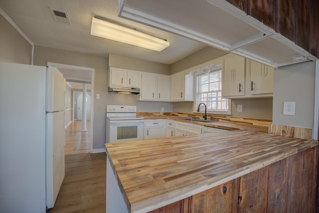 kitchen featuring white cabinetry, sink, white appliances, and butcher block countertops