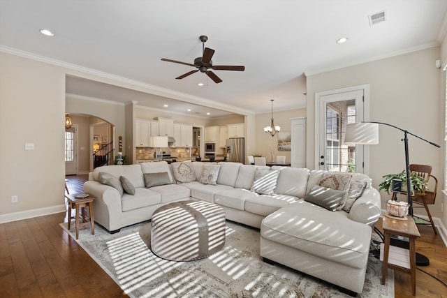 living room featuring dark wood-type flooring, a wealth of natural light, and ornamental molding