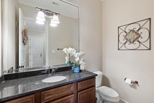 bathroom with vanity, crown molding, and toilet