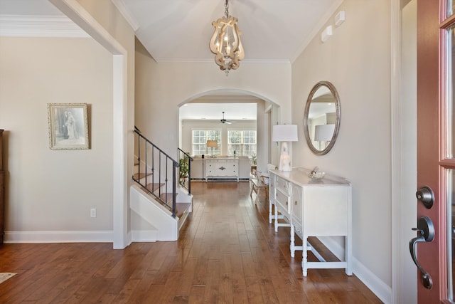 entrance foyer featuring crown molding, dark wood-type flooring, and a chandelier