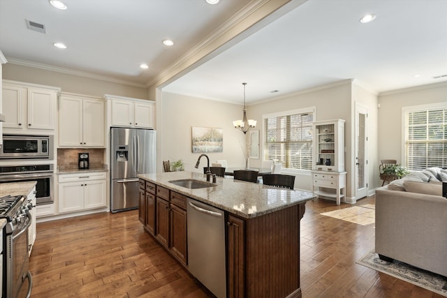 kitchen featuring pendant lighting, sink, dark wood-type flooring, stainless steel appliances, and light stone counters