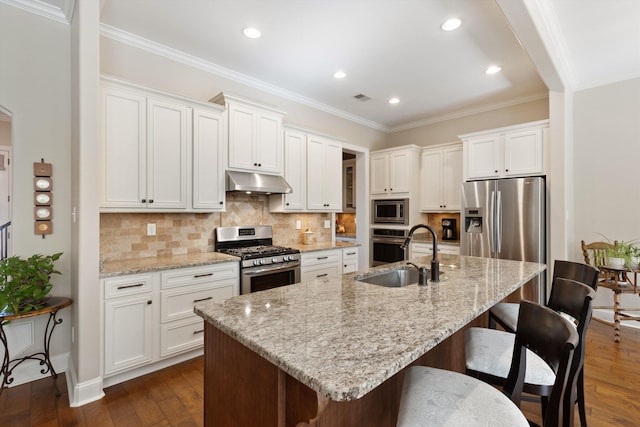 kitchen featuring a center island with sink, white cabinets, and appliances with stainless steel finishes