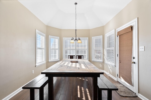 dining space featuring lofted ceiling, hardwood / wood-style floors, and a chandelier