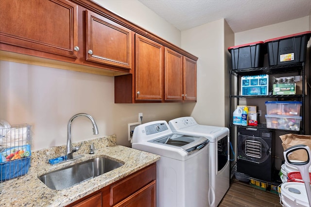 washroom featuring washer and dryer, sink, hardwood / wood-style flooring, cabinets, and a textured ceiling