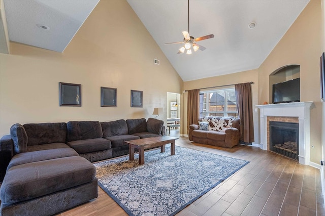 living room with hardwood / wood-style flooring, high vaulted ceiling, and ceiling fan