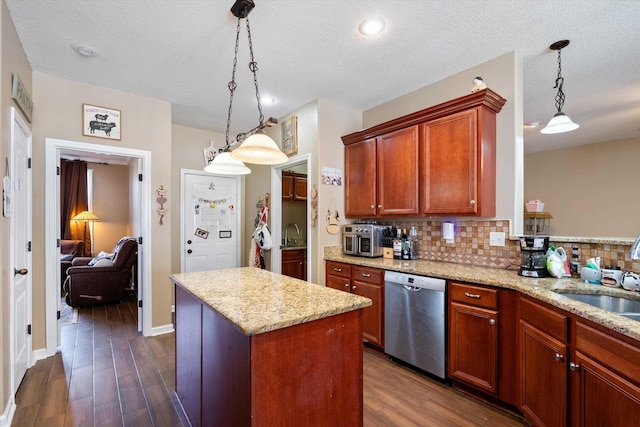 kitchen featuring light stone counters, dishwasher, a kitchen island, pendant lighting, and decorative backsplash