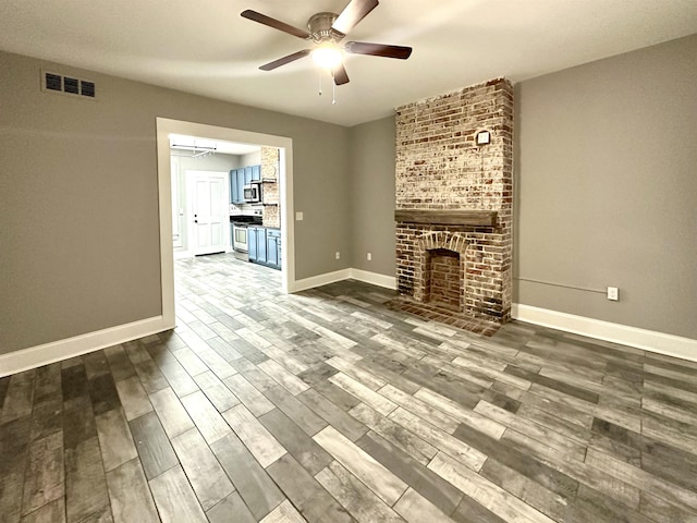 unfurnished living room with hardwood / wood-style flooring, ceiling fan, and a fireplace