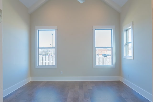 spare room with lofted ceiling with beams and dark wood-type flooring