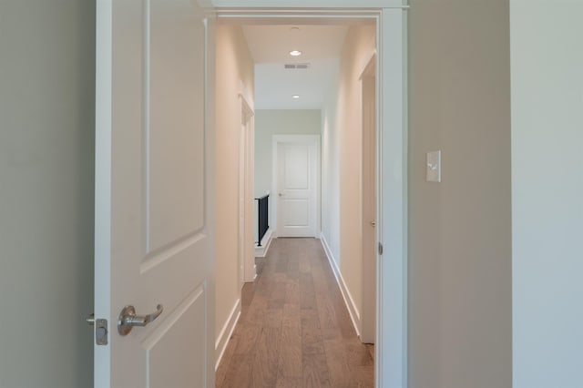 corridor with hardwood / wood-style flooring