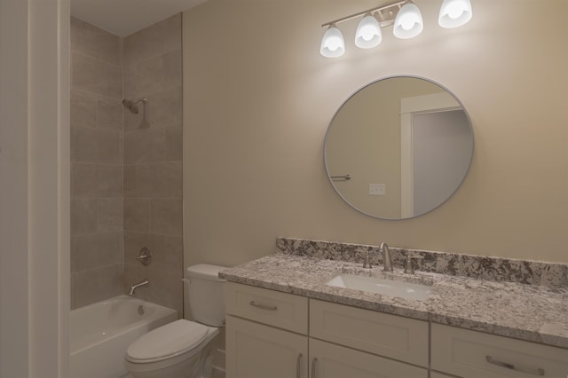 full bathroom featuring vanity, tiled shower / bath, and toilet