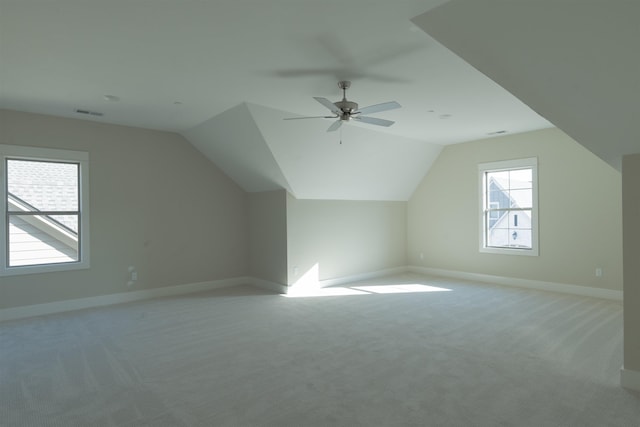 additional living space featuring vaulted ceiling, light colored carpet, and ceiling fan