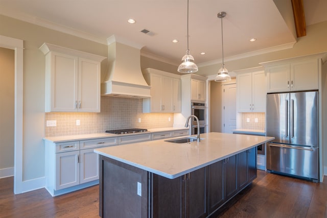 kitchen featuring white cabinetry, sink, premium range hood, and appliances with stainless steel finishes