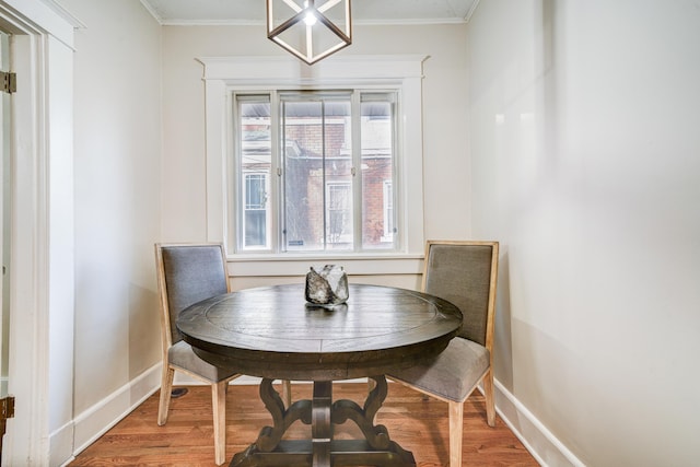 dining area with wood-type flooring and ornamental molding