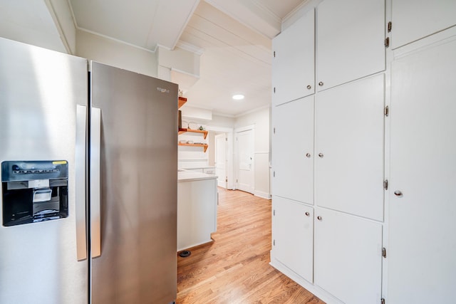 kitchen featuring light hardwood / wood-style flooring, crown molding, stainless steel fridge, and white cabinets