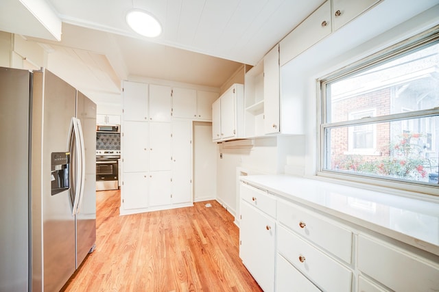 kitchen featuring white cabinetry, tasteful backsplash, stainless steel appliances, and light wood-type flooring