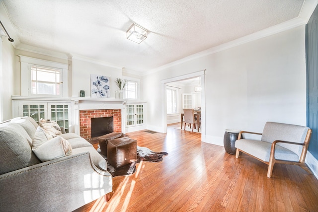 living room featuring ornamental molding, a textured ceiling, and light wood-type flooring