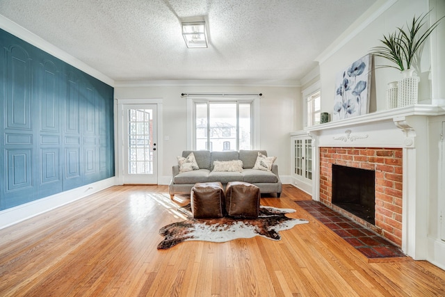 living room featuring crown molding, hardwood / wood-style floors, a textured ceiling, and a fireplace