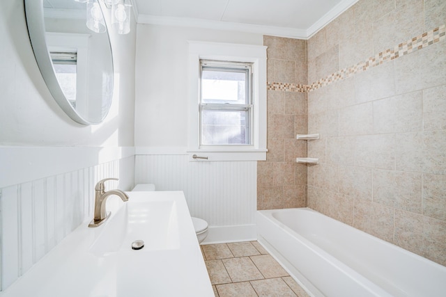 full bathroom featuring toilet, sink, crown molding, tiled shower / bath, and tile patterned flooring