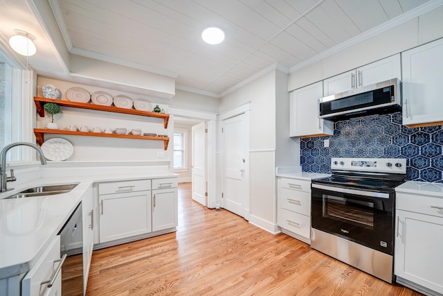 kitchen featuring white cabinetry, stainless steel appliances, crown molding, and sink