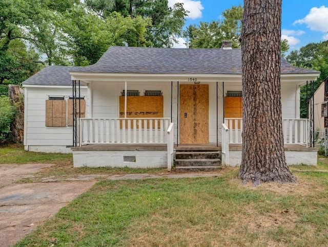 view of front facade with a front yard and covered porch