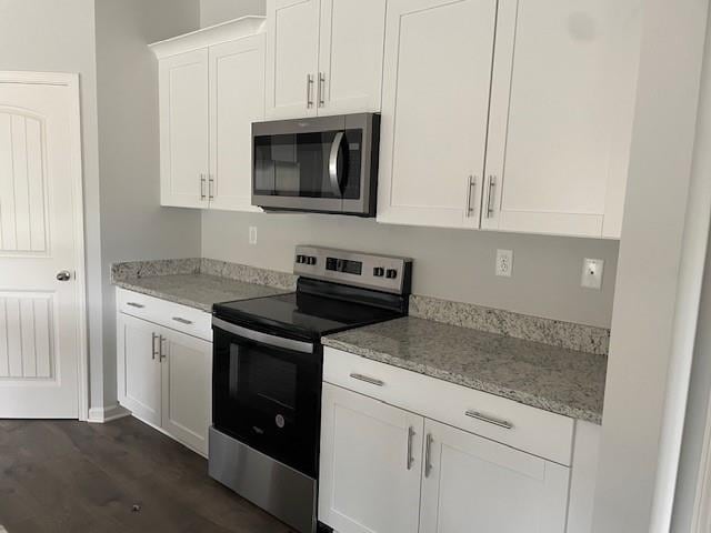 kitchen featuring light stone countertops, white cabinetry, appliances with stainless steel finishes, and dark hardwood / wood-style flooring