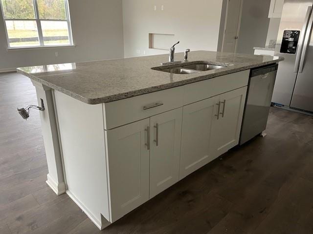 kitchen with light stone counters, stainless steel appliances, sink, and white cabinets