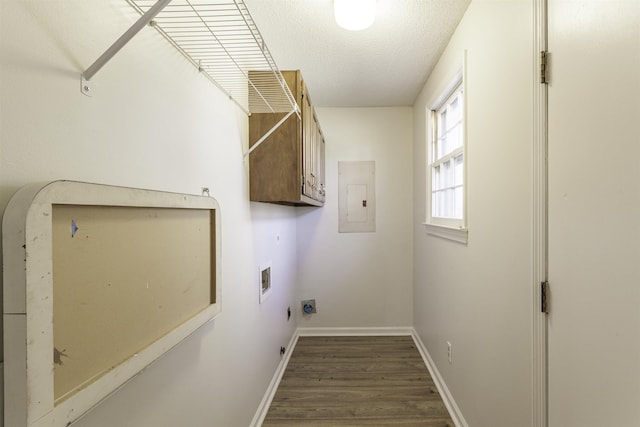 washroom with cabinets, electric panel, hookup for a washing machine, dark wood-type flooring, and a textured ceiling