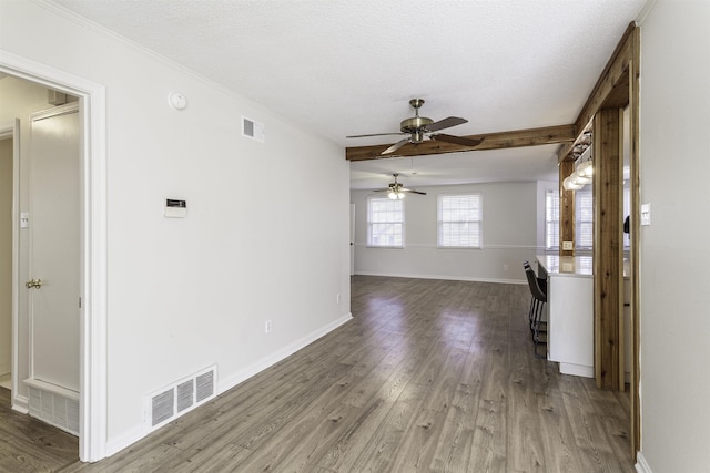 unfurnished living room featuring hardwood / wood-style flooring, ceiling fan, ornamental molding, and a textured ceiling