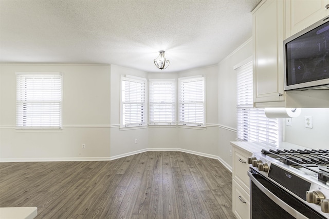 kitchen featuring white cabinets, hardwood / wood-style flooring, a textured ceiling, and appliances with stainless steel finishes