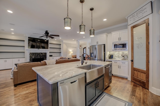 kitchen featuring white cabinetry, appliances with stainless steel finishes, sink, and an island with sink