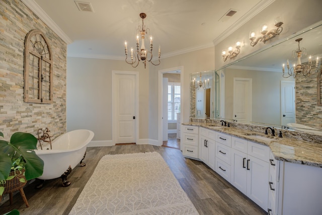 bathroom featuring a washtub, vanity, crown molding, and a chandelier