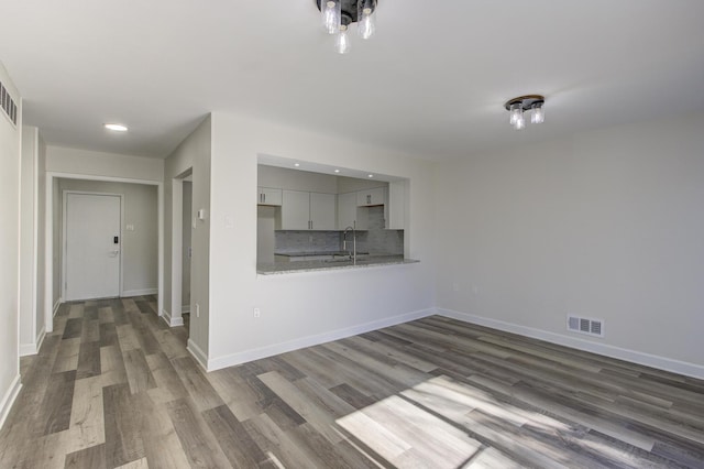 unfurnished living room with sink and dark hardwood / wood-style flooring