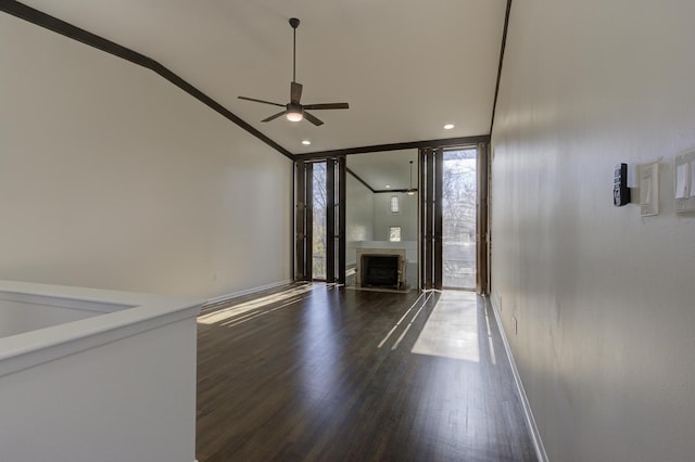 interior space featuring ceiling fan, ornamental molding, dark hardwood / wood-style floors, and a wall of windows