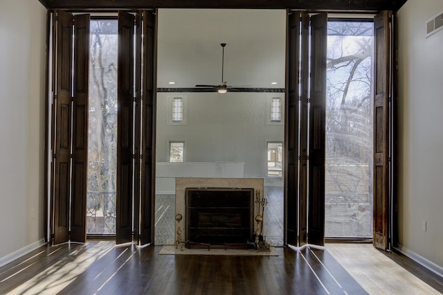 interior space featuring hardwood / wood-style flooring, a high end fireplace, and ceiling fan