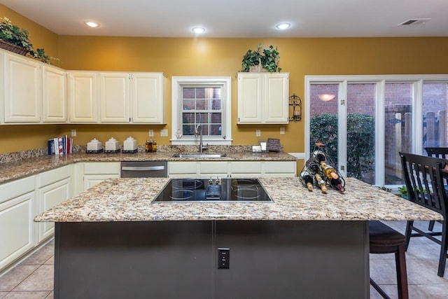 kitchen with sink, stainless steel dishwasher, white cabinets, and a kitchen island