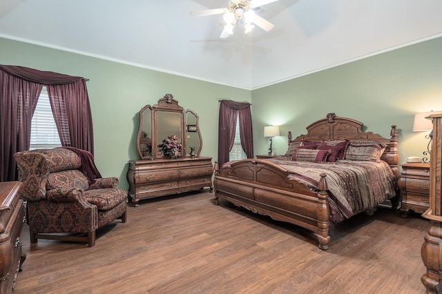 bedroom featuring ceiling fan, ornamental molding, wood-type flooring, and lofted ceiling