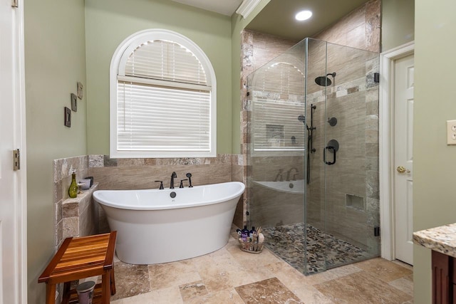 bathroom with tile walls and independent shower and bath